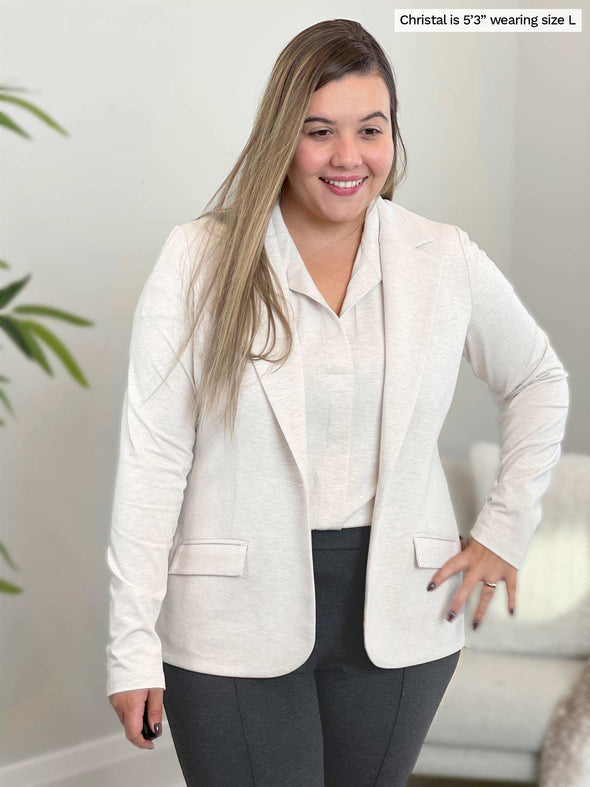 Woman smiling and looking down wearing Miik's Sienna girlfriend blazer in oatmeal melange with a matching colour top and charcoal pant