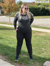 Woman smiling looking away wearing Miik's Silvie slouch pant in charcoal along with a long sleeve top in charcoal leopard print