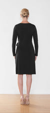 Woman standing with her back towards the camera wearing Miik's Sonya wrap dress in black.
