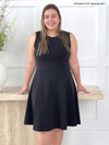Miik model Christal (five feet three, size large) smiling wearing Miik's Valerie sleeveless fit and flare dress in graphite