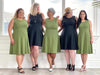 Group of five Mikk models all wearing the same dress: the Valerie sleeveless fit and flare dress in the two colours available: green moss and graphite. The image is showing all different body shapes and how is the dress fitting