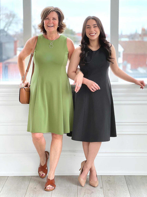 Miik model Yasmine (five feet tall, size extra small, petite) standing next to Miik founder Donna (five feet six, size small) both smiling and wearing Miik's Valerie sleeveless fit and flare dress in green moss and graphite