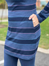 A close-up image of the pockets of Miik's Venice cowl pocket tunic in navy jewel tone stripe