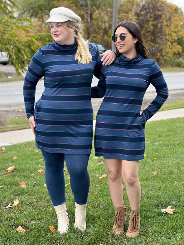 Two women standing outdoors and looking away while wearing Miik's Venice cowl pocket tunic in navy jewel tone stripe