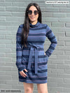 Woman smiling in front of a brick wall wearing Miik's Venice cowl pocket tunic in navy jewel tone stripe belted with a navy melange Blair belt and sunglasses