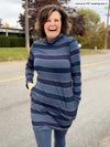 Woman smiling wearing Miik's Venice cowl pocket tunic in navy jewel tone stripe and leggings in navy melange
