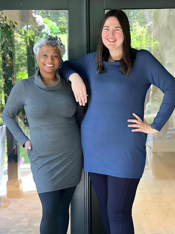 Two women standing next to each other in front of a door wearing Miik's Vienna cowl neck long sleeve tunic in charcoal and navy melange 