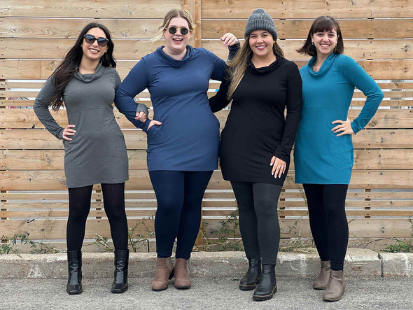 Group of women all wearing different colours of Miik's Vienna cowl pocket tunic: granite melange, navy melange, black and teal melange